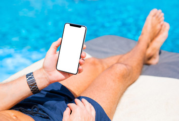 Poster - Man using mobile phone on vacation by the pool. Mobile phone mockup.