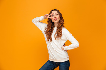 Poster - Funny brunette woman in sweater posing with arm on hip