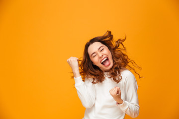 Poster - Happy screaming brunette woman in sweater rejoices with closed eyes