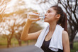 © geargodz - young sporty woman drinking water in park