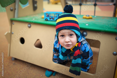 Valokuva Beautiful child sits in small house at the playground area