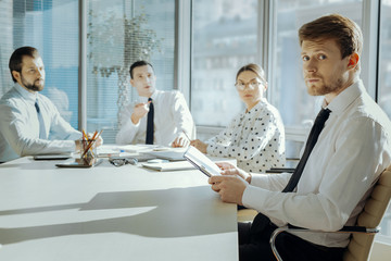 Poster - Ready for scolding. Handsome young manager sitting at the meeting with the board of directors and looking nervous, feeling some guilt and being reprimanded