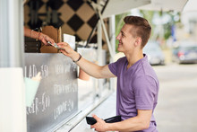 Happy Young Man Paying Money At Food Truck