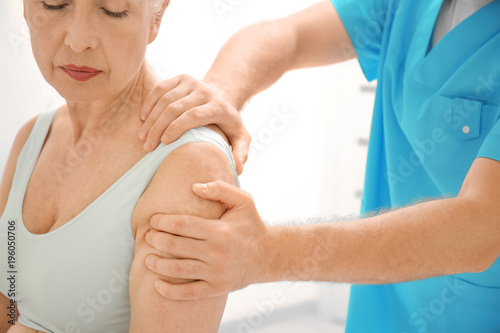 Fotografía Elderly woman getting shoulder massage at physical therapy office