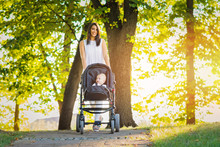 Young Mother Taking A Hike With Her Baby In Park In Autumn Or Spring
