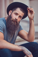 Wall Mural - A handsome hipster male with a stylish beard with a tattoo on hi