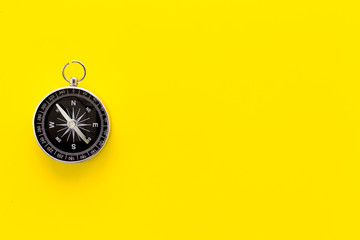 compass on yellow background top view copy space