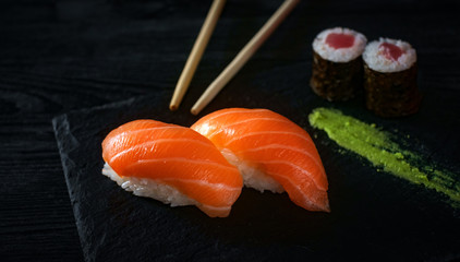 two sushi with salmon on stone