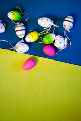 Wall Mural - colorful painted pink, blue, green easter eggs on modern blue and yellow background