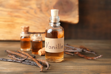 Wall Mural - Glass bottle with vanilla extract on wooden table