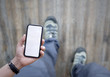 man on walking and holding smartphone with white blank screen