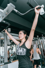 Wall Mural - Woman doing exercises on a pull-up machine