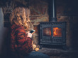 © LoloStock - Woman using smart phone by the fireplace