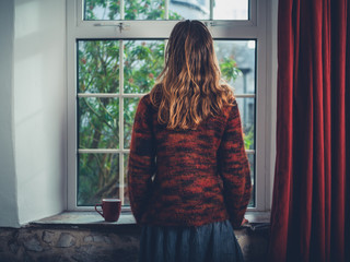 Wall Mural - Woman with cup of tea by the window