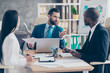 © deagreez - Attractive, handsome, stylish, elegant man in classic suit explaining something to his partners, three colleagues sitting in workstation, solving problems, finding solution, expertising results
