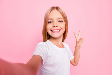 Sticker - Close up portrait of cute lovely sweet funky adorable beautiful charming with toothy with blonde hairstyle beaming smile girl making v-sign gesture white tshirt isolated on pink background