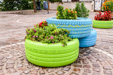 Old Tires That Are Painted In Assorted Colors And Used For A Flower Planter, Modern Garden