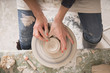 © Gonzales Photo - A ceremic artist shaping pottery clay on a pottery wheel in a ceramic workshop.