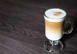 A hot and creamy Macchiato Coffee in a tall glass on a clean background