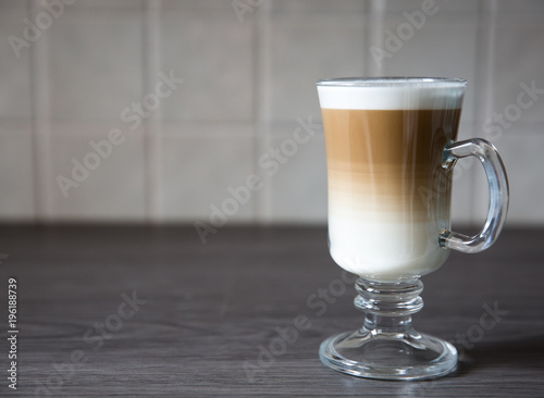 Plakat Gorąca i kremowa kawa Macchiato w wysokiej szklance na czystym tle