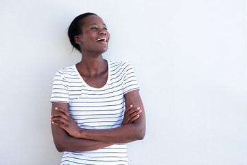 Wall Mural - happy african american woman laughing with arms crossed by white wall