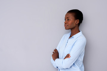 Wall Mural - confident african woman in shirt standing with arms crossed by gray wall