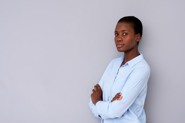 Wall Mural - young african woman standing with arms crossed and staring at camera