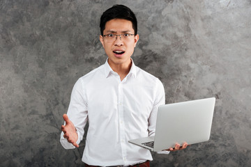 Canvas Print - Portrait of a confused young asian man dressed in shirt