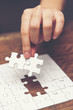 © chokniti - Business solutions, success and strategy concept. Businessman hand connecting jigsaw puzzle.