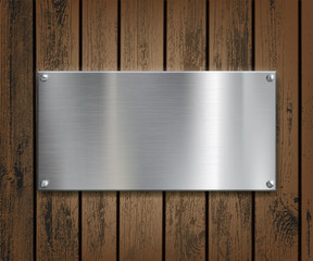 Wall Mural - Metal plate on a wooden background.