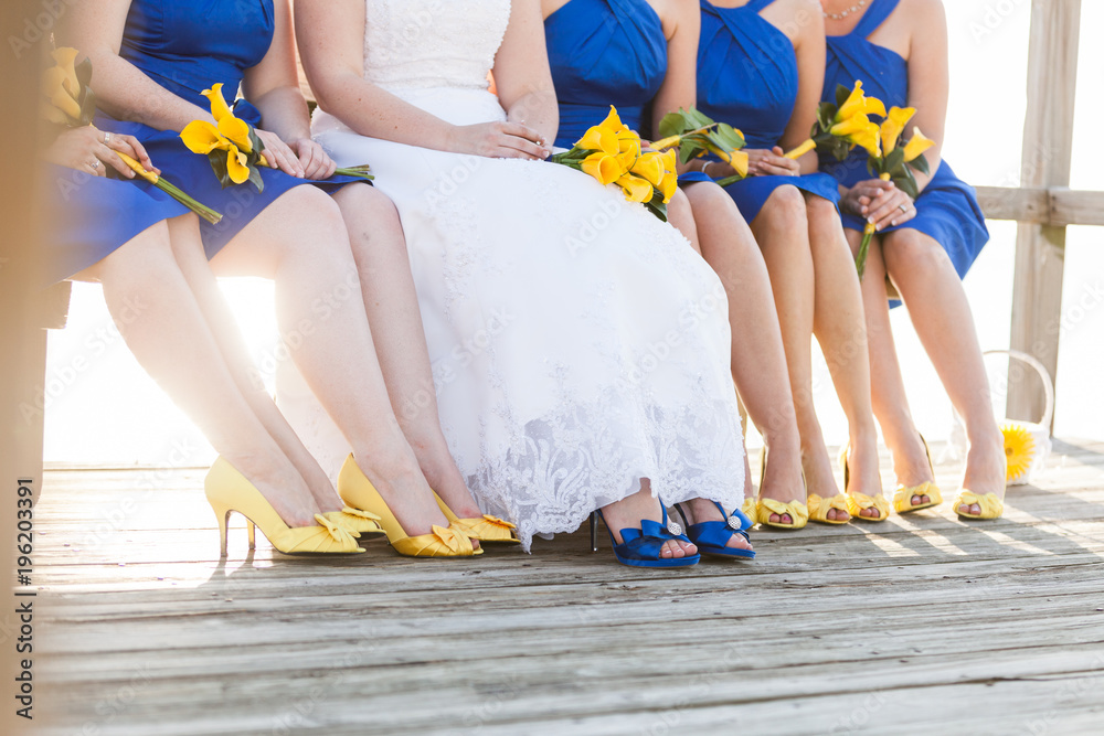 Bride with Bridesmaids in Blue dresses with Yellow Flowers and Shoes on a  Dock Stock Photo | Adobe Stock