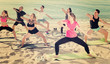 © JackF - People exercising yoga poses on beach