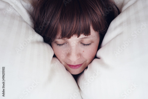 Fotografie, Obraz Mujer joven durmiendo en su cama entre almohadas
