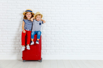 happy laughing children  with suitcase going on a trip