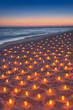 Sunset ocean sandy beach decorated with lot flare lights of candles. Romantic sea vacation or honeymoon concept vertical background.