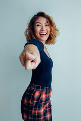 Wall Mural - Portrait of smiling Asian woman pointing at camera