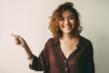 Wall Mural - Portrait of smiling young woman showing direction