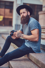 Wall Mural - A handsome hipster male with a stylish beard and tattoo on his a