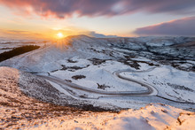 Long Winding Rural Road In The Peak District With Snow And Beautiful Sunset.