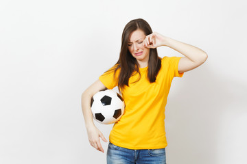 Wall Mural - Beautiful European young upset crying woman, football fan or player in yellow uniform holding soccer ball isolated on white background. Sport, play football, health, healthy lifestyle concept.