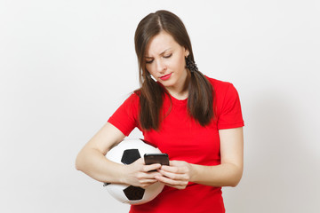 Wall Mural - European young angry screaming woman, football fan or player in yellow uniform send sms on mobile phone, hold soccer ball isolated on white background. Sport, play football, healthy lifestyle concept.