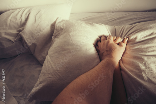 Zdjęcie XXL mężczyzna ściska dłoń kobiety na białych prześcieradłach. Pasja podczas uprawiania miłości