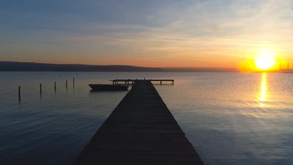 Wall Mural - Aerial drone flight over small dock and boat at the lake