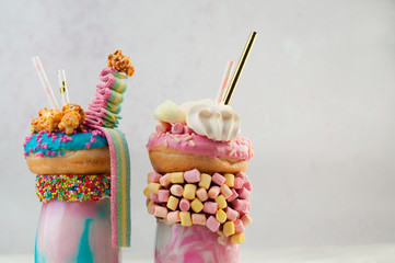 Wall Mural - Close up of  two freak shakes topping with blue and pink donuts