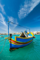 Wall Mural - Beautiful painted fishing boat on turquoise water in Marsaxlokk,Malta