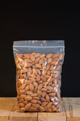 Wall Mural - Almond in a zipper bag on wood table.