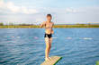 © Natali - sporty cute young boy jumps very high from pier and having fun on his vacation by the sea