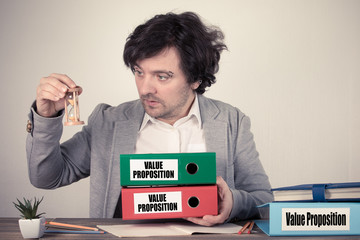 Wall Mural - Value Proposition text on the binders, worried bussinesman thinking by the work desk