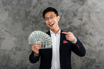 Wall Mural - Portrait of a smiling young asian man dressed in suit