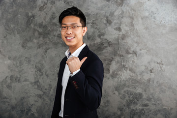 Wall Mural - Portrait of a smiling young asian man dressed in suit